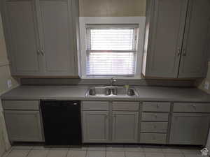 Kitchen featuring dishwasher, gray cabinets, light tile patterned floors, and sink