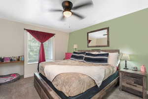 Carpeted bedroom featuring ceiling fan