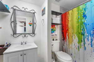 Bathroom with vanity, toilet, and walk in shower