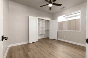 Unfurnished bedroom with ceiling fan, a closet, and light hardwood / wood-style floors