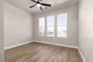 Empty room with ceiling fan and light hardwood / wood-style flooring