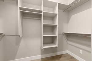 Spacious closet with hardwood / wood-style flooring