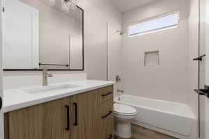 Full bathroom featuring hardwood / wood-style floors, vanity, shower / bath combination, and toilet