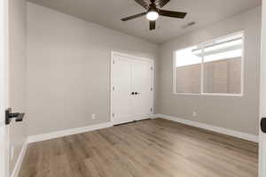 Unfurnished bedroom with ceiling fan, light hardwood / wood-style flooring, and a closet