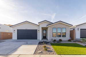 View of front of property with a front yard and a garage