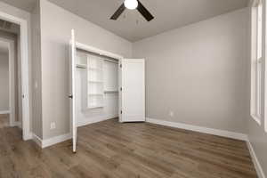 Unfurnished bedroom featuring a closet, ceiling fan, and hardwood / wood-style flooring