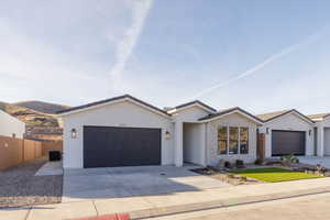 Single story home with a mountain view, central AC unit, and a garage