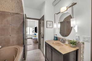 Bathroom with tile patterned flooring, vanity, and a bath