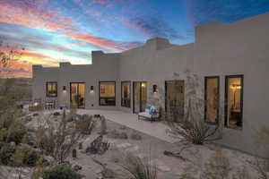 Back house at dusk with a patio area