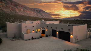 Pueblo-style house featuring a mountain view and a garage