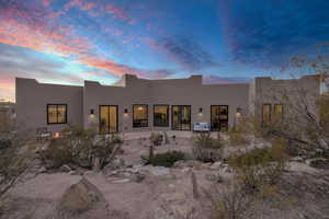 Back house at dusk featuring a patio area