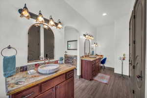 Bathroom with hardwood / wood-style flooring, vanity, and lofted ceiling