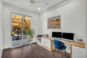 Office featuring dark hardwood / wood-style floors, ceiling fan, and built in desk