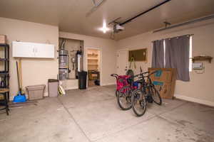 Garage featuring secured water heater and a garage door opener