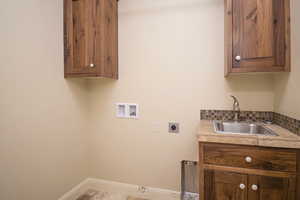 Laundry room with sink, hookup for a washing machine, cabinets, and hookup for an electric dryer