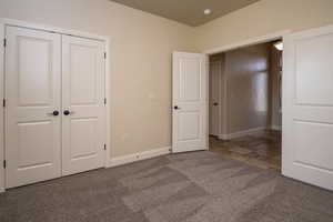 Unfurnished bedroom featuring carpet and a closet