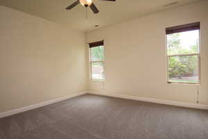 Carpeted empty room with ceiling fan