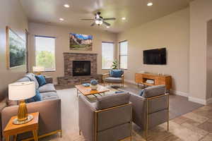 Living room with a stone fireplace and ceiling fan