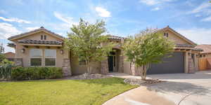 Mediterranean / spanish house with a garage and a front lawn