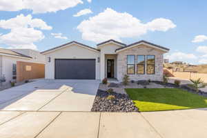 View of front of house featuring a garage and a front lawn