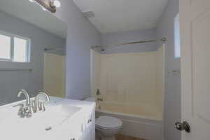 Full bathroom with toilet, vanity, and bathing tub / shower combination