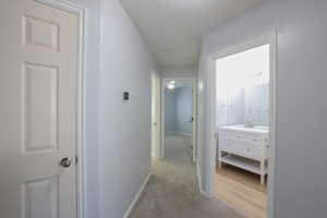 Hallway featuring light carpet and sink