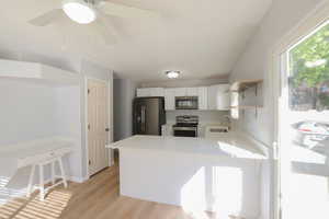 Kitchen featuring white cabinets, sink, light hardwood / wood-style flooring, appliances with stainless steel finishes, and kitchen peninsula