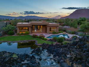 Back house at dusk with a mountain view and a patio area