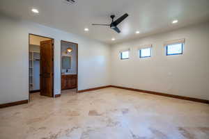 Unfurnished bedroom featuring sink, ensuite bath, ceiling fan, a spacious closet, and a closet