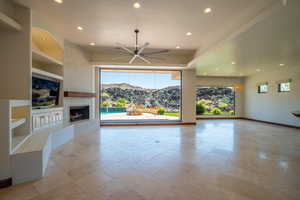 Unfurnished living room featuring ceiling fan and built in features