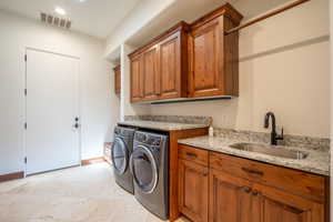 Laundry room with cabinets, separate washer and dryer, and sink