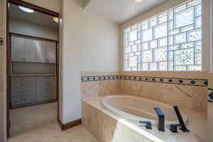 Bathroom featuring tile patterned flooring and a relaxing tiled tub