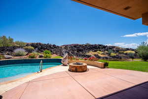 View of swimming pool with a patio area and an outdoor fire pit