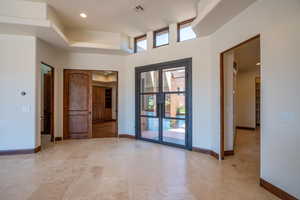 Unfurnished room featuring french doors and a towering ceiling