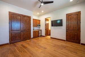 Interior space featuring ceiling fan, sink, light wood-type flooring, and stainless steel appliances