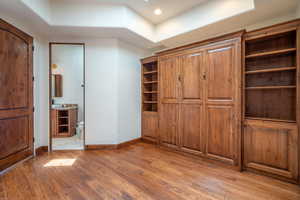 Unfurnished bedroom featuring ensuite bathroom and light hardwood / wood-style floors