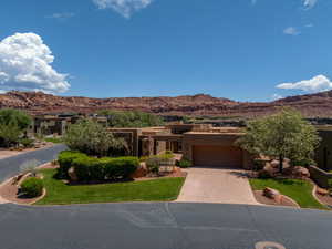 View of front of property with a mountain view, a garage, and a front yard