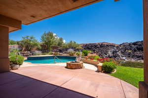 View of swimming pool featuring a patio and a fire pit