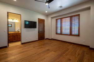 Unfurnished bedroom featuring ensuite bath, ceiling fan, light hardwood / wood-style flooring, and sink