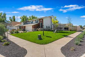 View of front of home featuring a trampoline, a garage, and a front lawn