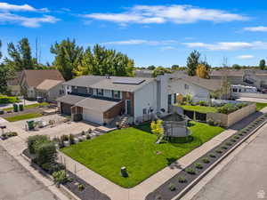 View of front facade with solar panels, a trampoline, a garage, and a front lawn