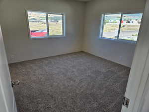 Empty room featuring carpet and plenty of natural light