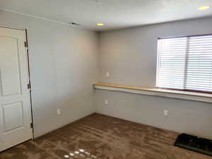 Spare room with dark colored carpet