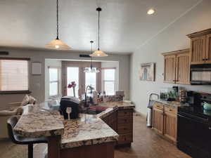 Kitchen with a wealth of natural light, sink, black appliances, and vaulted ceiling