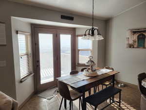 Dining area with tile patterned floors and a notable chandelier
