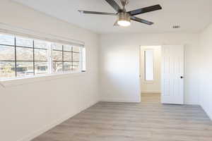 Unfurnished room with ceiling fan and light wood-type flooring