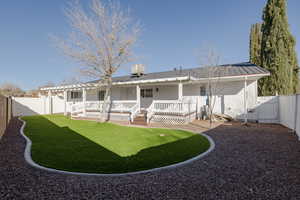 Rear view of property with a lawn and a wooden deck