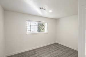 Empty room featuring hardwood / wood-style flooring and a textured ceiling