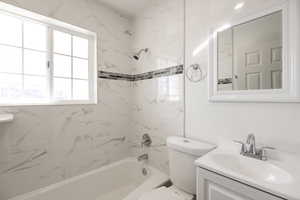 Full bathroom with vanity, toilet, and tiled shower / bath combo