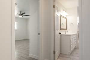 Bathroom featuring vanity, wood-type flooring, a textured ceiling, and ceiling fan